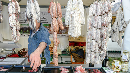 Man cut pieces of salami to offer customers tastings